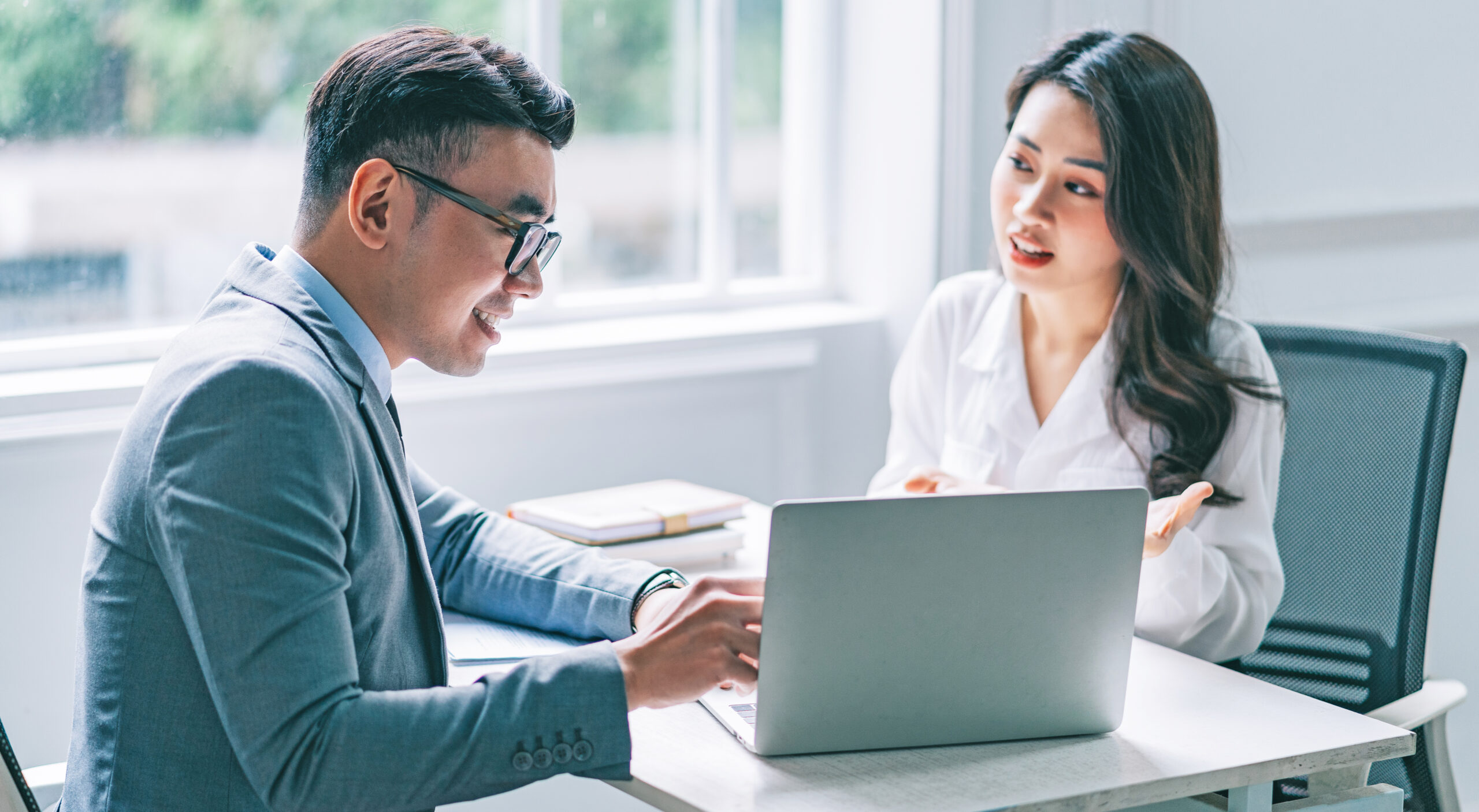 Two Asian businesspeople working at office