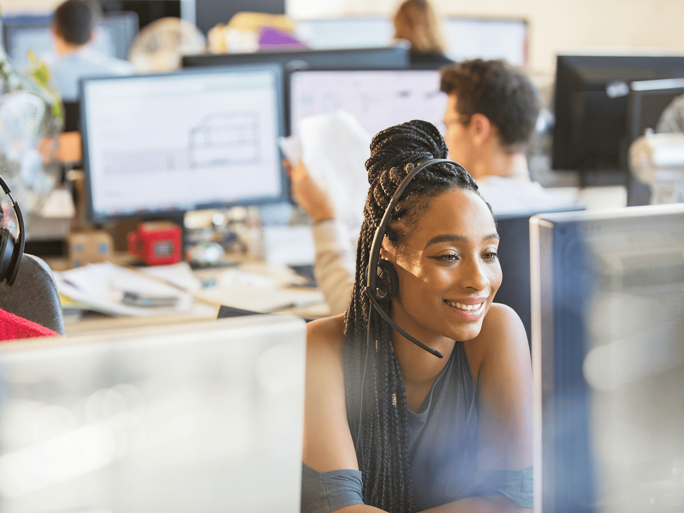 Smiling businesswoman with headset working at computer in office